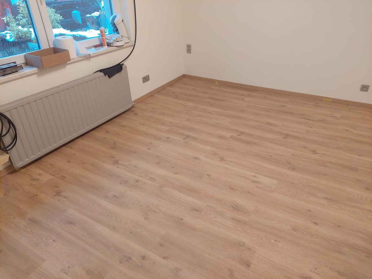 Neu verlegter Boden mit Sockelleisten in einem hellen Wohnraum