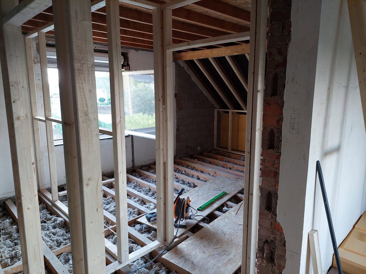 Dachgeschoss-Ausbau mit Holzständerwerk und frisch verlegten OSB-Platten auf den Balken
