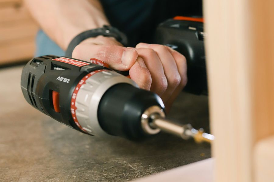 Akkuschrauber bei der Montage an einem Holzgestell, typische Hausmeister-Kleinreparatur